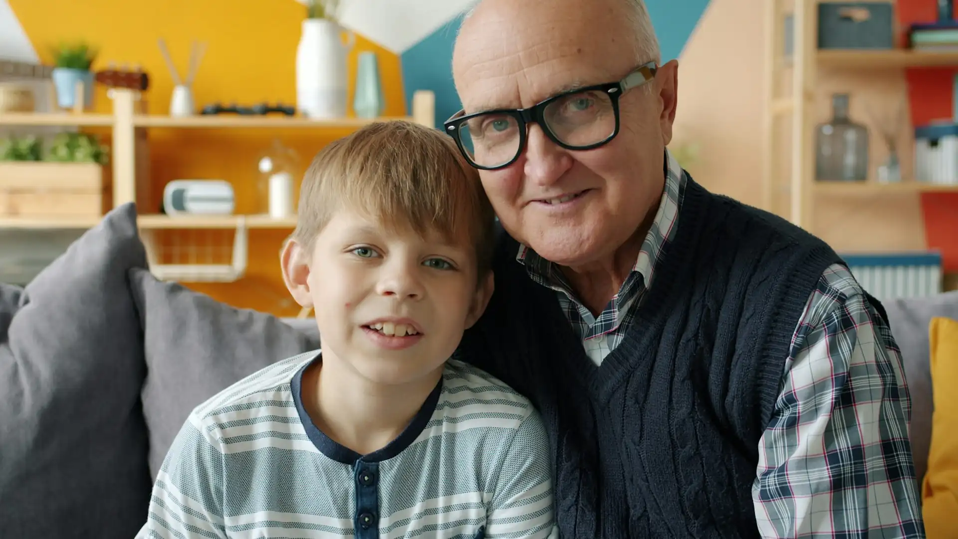 Un abuelo y su nieto sentados en un sofá, vistos con visión normal